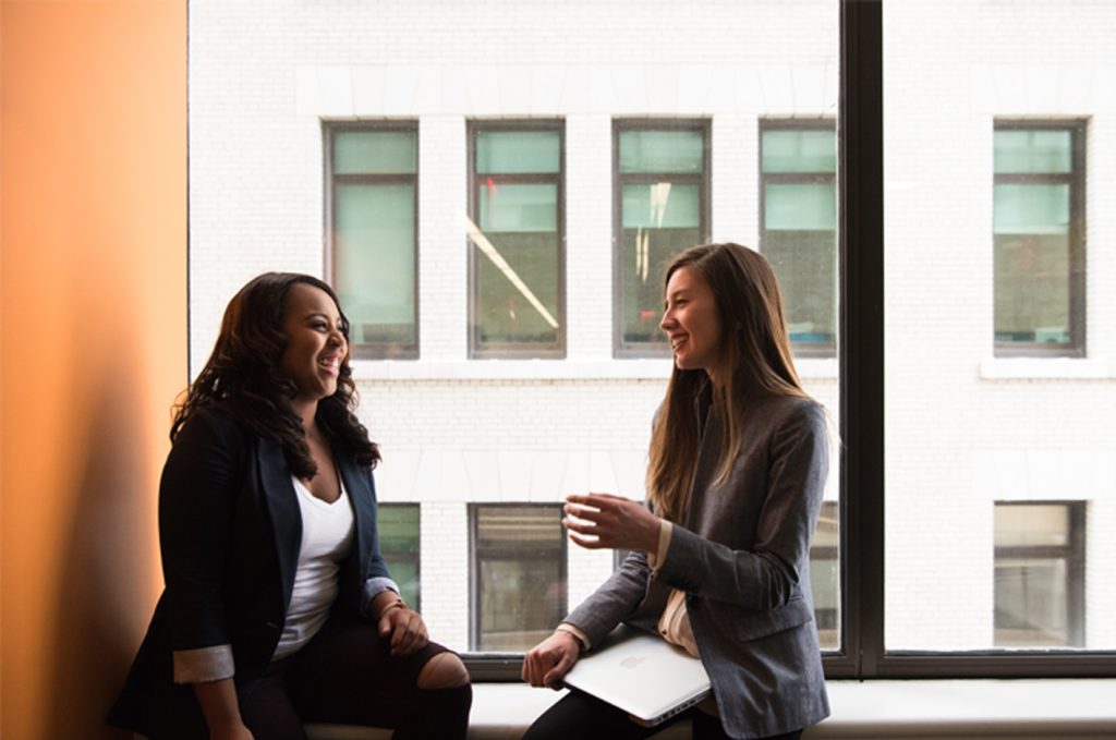 Two people laughing together at work