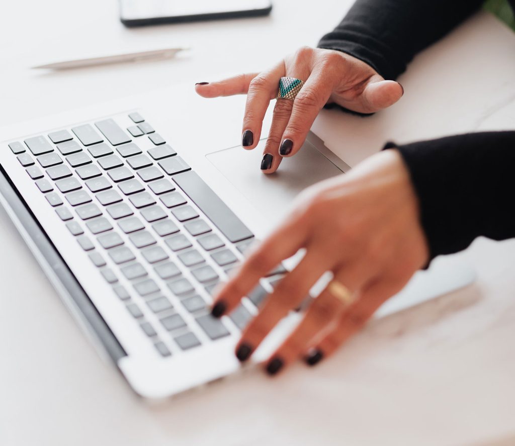 Someones hands using their laptop