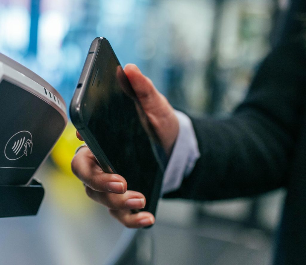 A person making a contactless payment using their phone